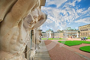 Closeup naked faunus smiling statue crop with fountain and garden at Zwinger palace in Dresden