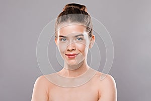 Closeup of naked smiling woman over grey studio background