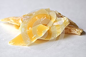 A closeup of a natural beeswax shavings for cosmetic use and candlemaking isolated on white