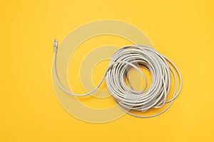 Closeup RJ45 Network internet cable hank on a yellow background. Concept, flat lay