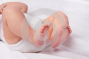Closeup, newborn baby or feet for relax, bed and nap for healthy childhood, care and development. Bare foot, leg and