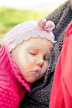 Closeup of newborn baby sleeping peacefully over the mother chest.