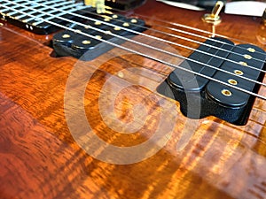 Closeup nickel stings and black pickup the orange guitar.