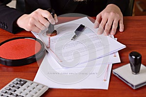 Closeup on notary's public hands stamping the testament and last will