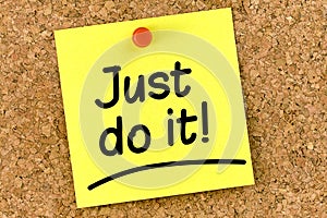 Closeup note on corkboard with just do it message on it