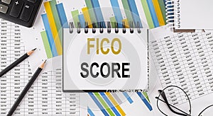 Closeup a notebook with text FICO SCORE , business concept image on chart background