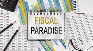 Closeup a notebook with text FISCAL PARADISE , business concept image on chart background