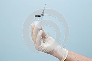 Closeup on nurse`s hand holding syringe and vaccine.