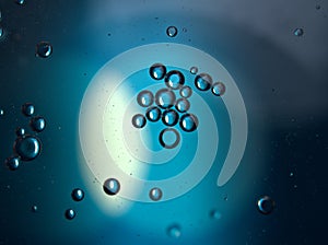 Closeup oil droplets with blue light background and shiny