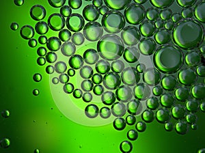 Closeup oil droplets with green light background and shiny