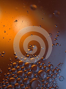 Closeup oil droplets with orange light background and shiny