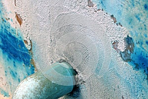 Closeup of old blue paint on a cement wall with a green pvc pipe water, abstract background