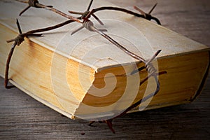 Old book wrapped with rusty barbed wire