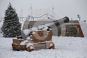 Closeup of an old cannon on a snow-covered winter background