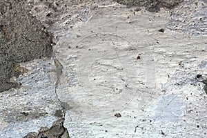 Closeup of old cement wall with weathered white paint