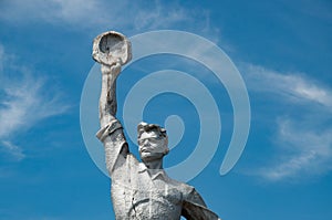 Closeup of old dilapidated stone statue of Soviet brave worker. Social realism monument in Odessa countryside of Ukraine. Monument