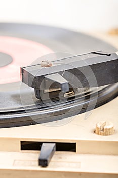 Closeup of old and dusty vinyl record player with arm and needle in focus