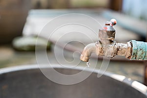 Closeup old faucet with water leaking