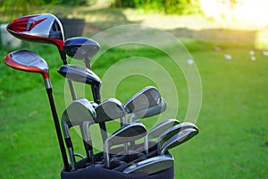 Closeup old golf bags on green. Set of golf clubs over green field background