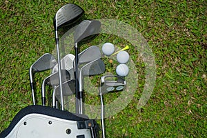 Closeup old golf bags on green. Set of golf clubs over green field background