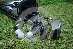 Closeup old golf bags on green. Set of golf clubs over green field background