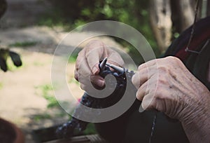 closeup on old lady hands to knitting