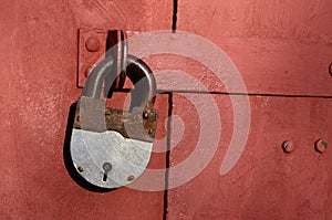 Closeup of old lock on red metal garage door