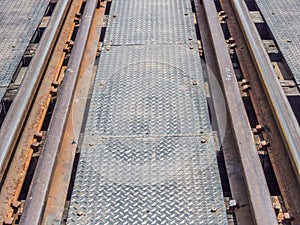 Closeup of an old railway track on steel bridge