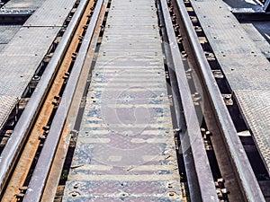 Closeup of an old railway track on steel bridge