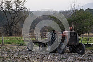Closeup of an old and rusty tractor in the middle of a field on a gloomy day