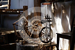 Closeup of old spinning wheels on tables under the sunlight in an aged building