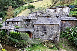 Closeup of old stone houses in the old village of Os Teixois in Asturias, Spain photo