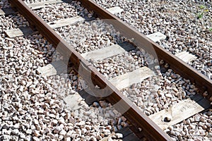 Closeup of an old train railway with wooden sleepers and stone floor
