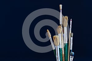 Closeup of paint brushes isolated on blue background