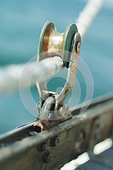 Closeup of old vintage metal yacht block with the rope, used to