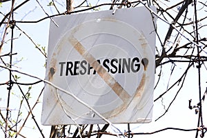 Closeup of old and weathered No trespassing sign posted to wire
