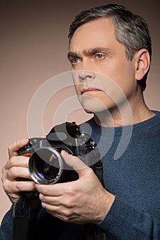 Closeup of older man holding camera.
