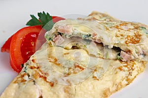Closeup of omelet with ham and vegetables.