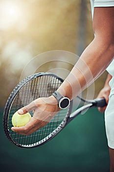 Closeup of one unknown indian tennis player getting ready to serve on court. Ethnic fit athlete holding a racket and a