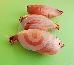 Three small onions over green table. Closeup of three onions.