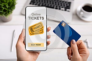 Woman holding smartphone with online tickets app and credit card photo