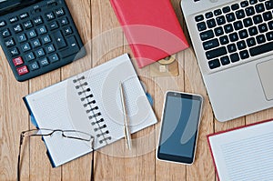Closeup open notebook, laptop, calculator, pen, smartphone on a