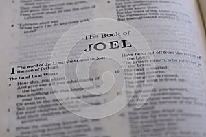 Closeup of an open page of the book of joel with partly blurred text