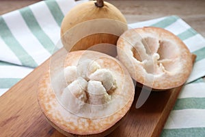 Closeup of Opened Fresh Cotton Fruit or Santol Fruit with Whole Fruit in Background