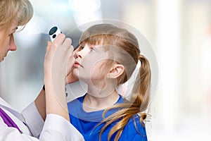 A closeup of an ophthalmologist examining the eyes of a child