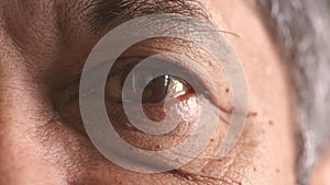 Closeup for optic vision exam of an older man looking for a treatment to improve eyesight at optometrist. Face portrait