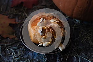 Closeup of orange pumpkin inside clean out with many seeds on a rustic table in preparation for making a jack-o-lantern