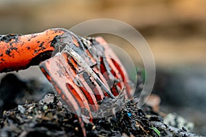Closeup orange rake on pile of dirty plastic waste on blurred background. Beach environmental pollution concept Clean up rubbish