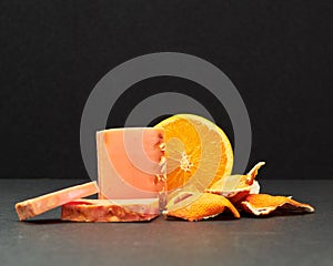Closeup of orange-scented soap bars against a dark background