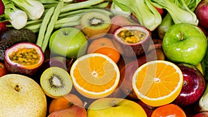 Closeup orange slice with group of ripe fruits and vegetables